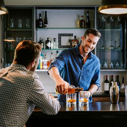 Individual Pouring a Drink in the Double Old-Fashioned Glass at the Bar